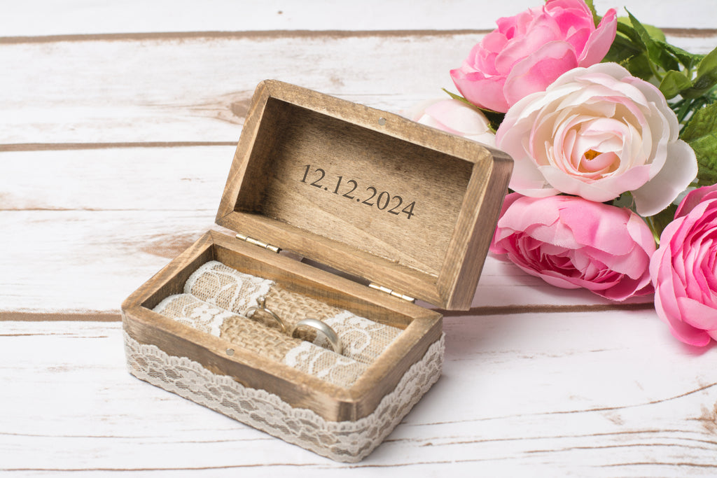 Geöffnete Trauringbox aus Holz mit graviertem Hochzeitsdatum