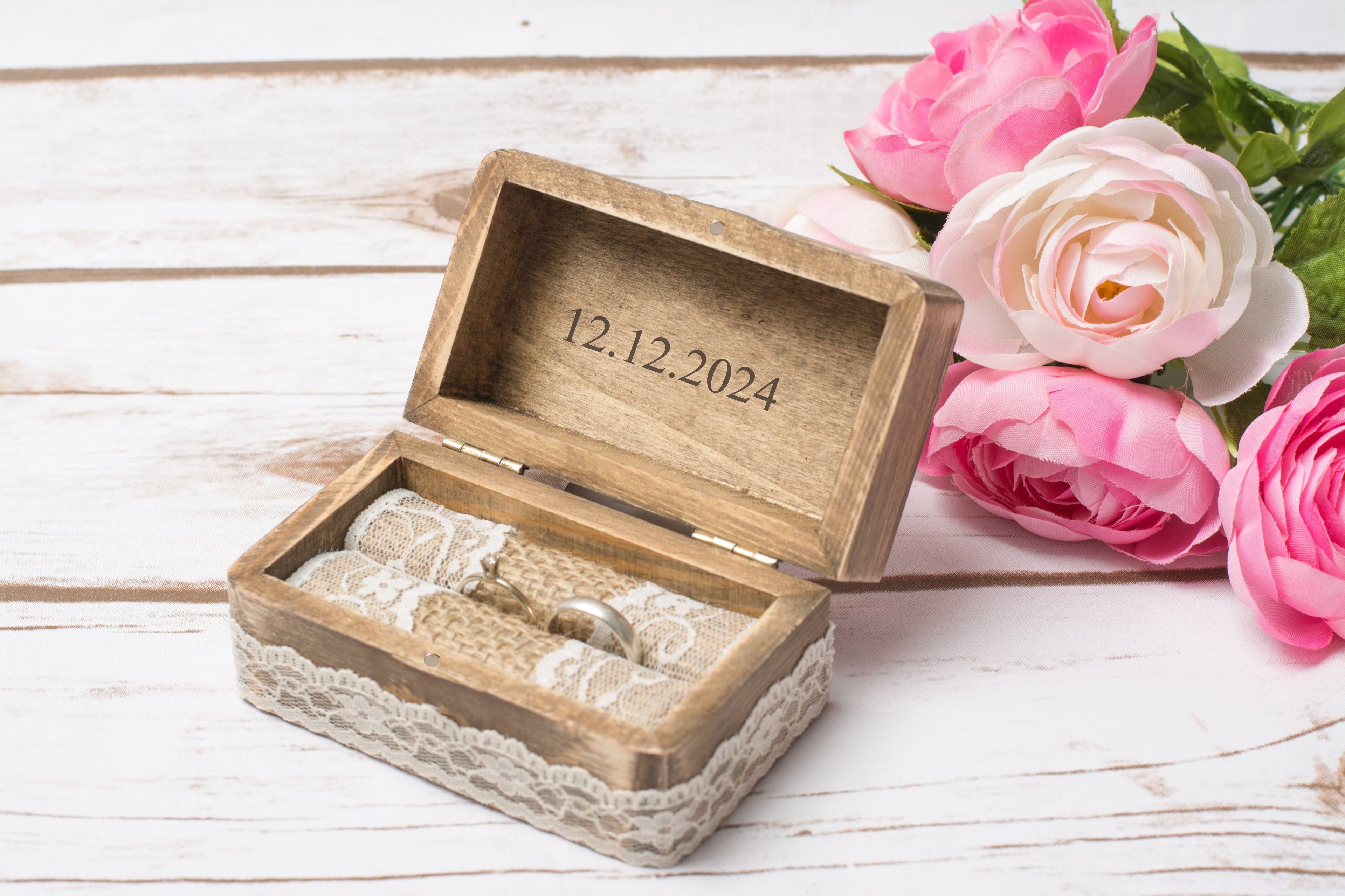 Geöffnete Trauringbox aus Holz mit graviertem Hochzeitsdatum